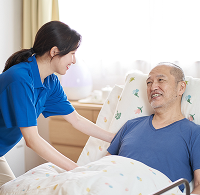 介護写真「ベッドに寝るおじいさん」